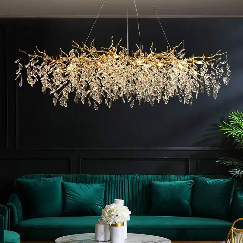 Golden leaf-shaped decorbites crystal chandelier with clear crystal droplets above teal velvet sofa for dining room