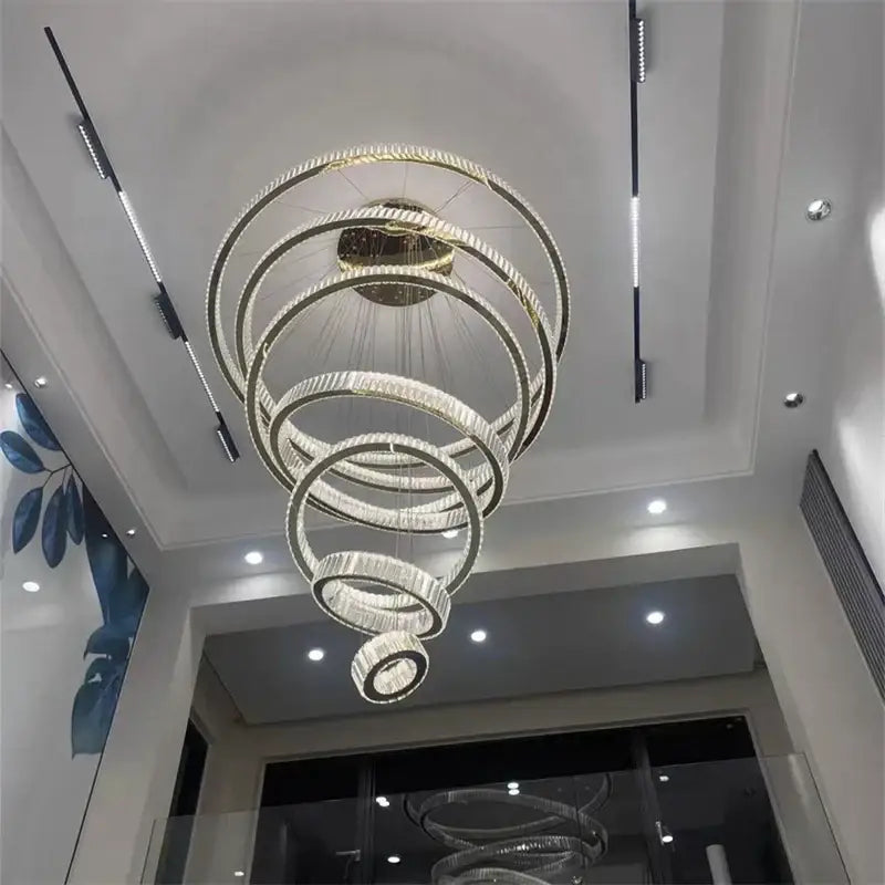 A modern decorbites crystal chandelier with concentric rings, clear crystals, and polished gold finish LED pendant light