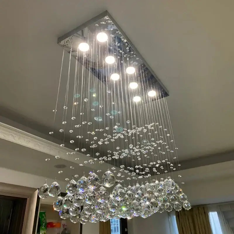A decorbites crystal chandelier led pendant light with sleek chrome frame and cascading crystal droplets for living room use