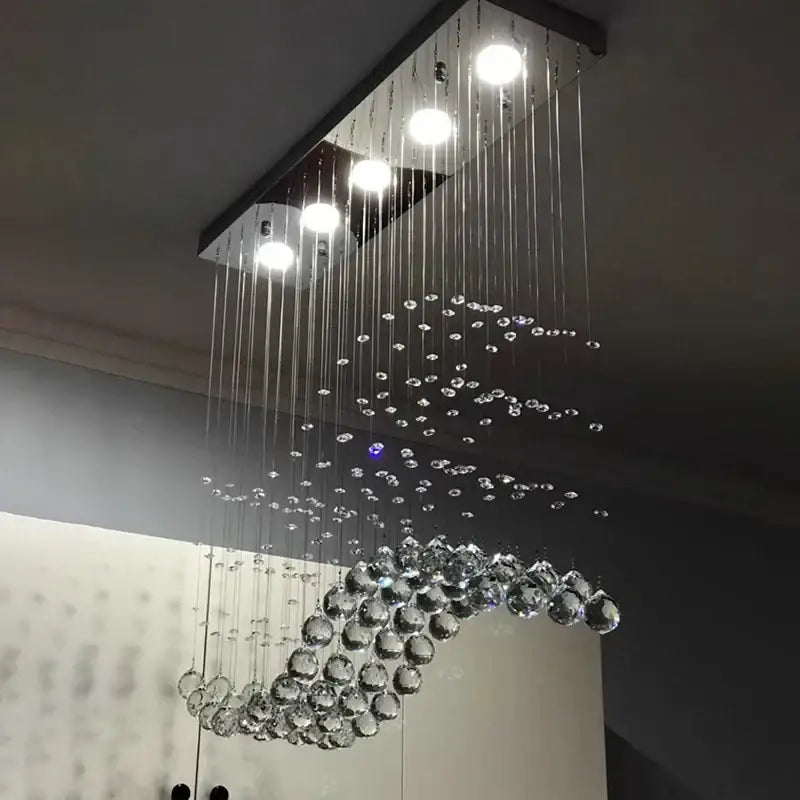 A modern decorbites crystal chandelier led pendant light with a sleek black frame and clear crystal beads for living room