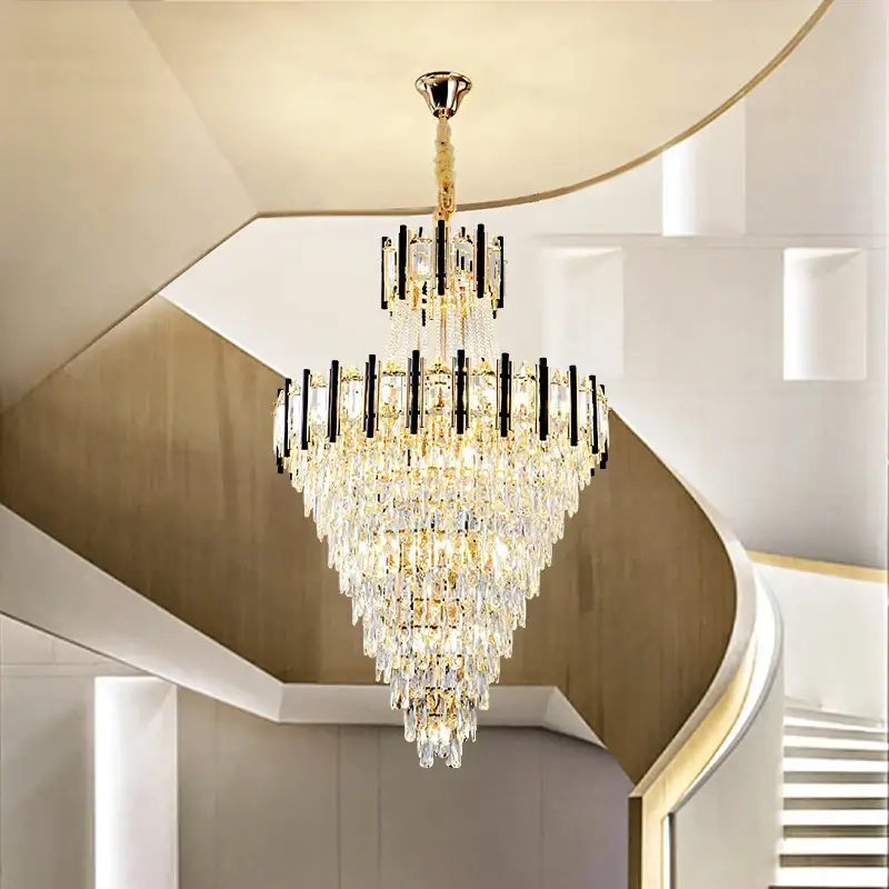 A decorbites crystal chandelier light with multi-tiered crystal design gold accents and black bars above curved staircase