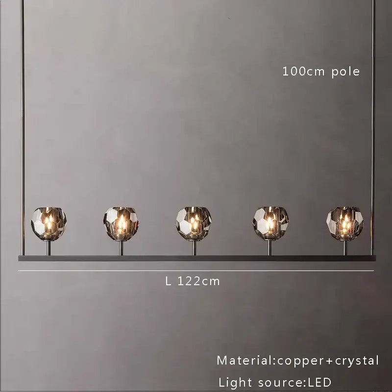 Modern five-light crystal chandelier lights with faceted crystal globes and copper accents for kitchen island decor