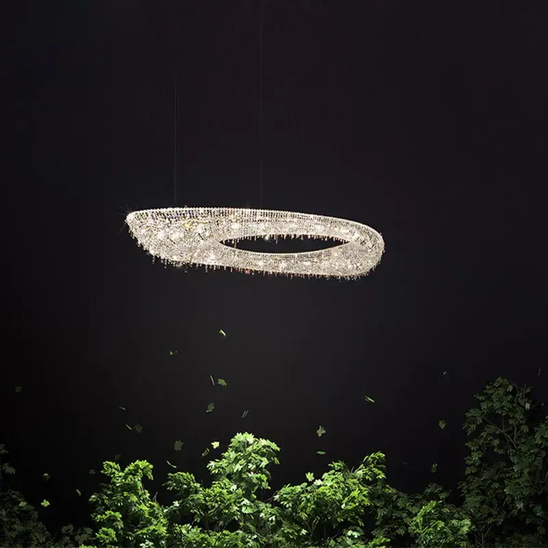 A decorbites crystal chandelier luminaire featuring a sparkling oval design with clear crystals and dangling droplets