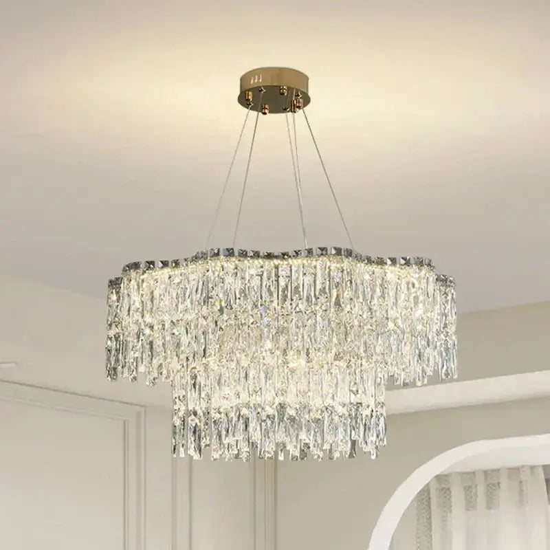 A modern multi-tiered decorbites crystal chandelier with gold-toned ceiling mount and hanging chains for luxury lighting