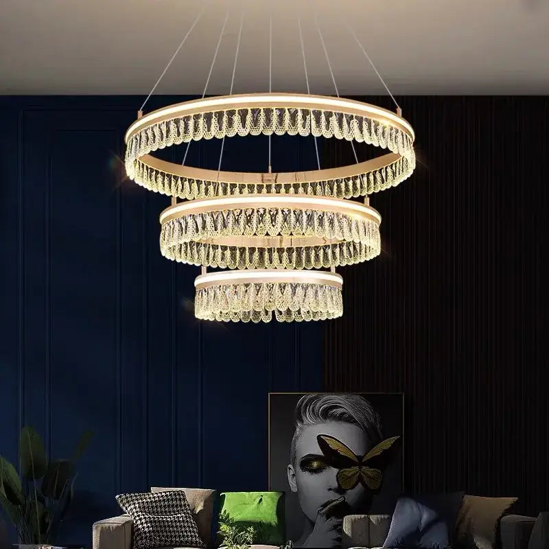 A modern three-tiered decorbites crystal chandelier with cascading crystal droplets and warm led lighting for luxury spaces