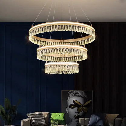 A modern three-tiered decorbites crystal chandelier with cascading crystal droplets and warm led lighting for luxury spaces