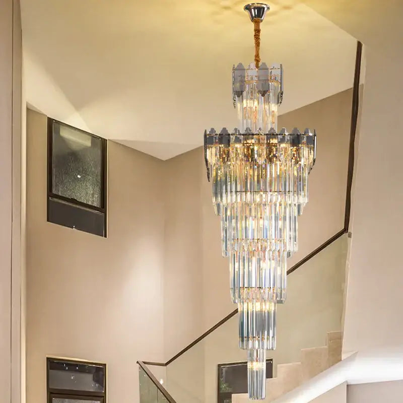 A multi-tiered decorbites crystal chandelier with cascading clear and frosted glass rods and brass ceiling mount