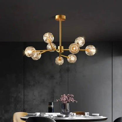 Gold-toned decorbites crystal chandelier with multiple faceted crystal globe bulbs for luxury living and dining rooms