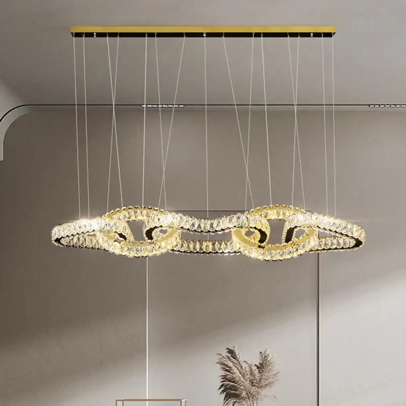 Gold-toned decorbites crystal chandelier with intertwined crystal rings for luxury living and dining room lighting