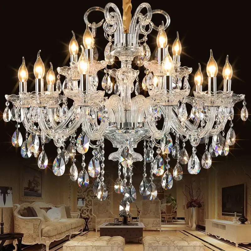 A decorbites crystal chandelier with multiple tiers of teardrop crystals and silver arms illuminated by warm bulbs