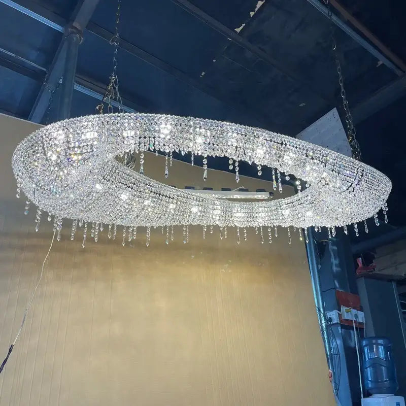A dazzling decorbites crystal chandelier with double-ring teardrop crystals and polished metallic frame for living room