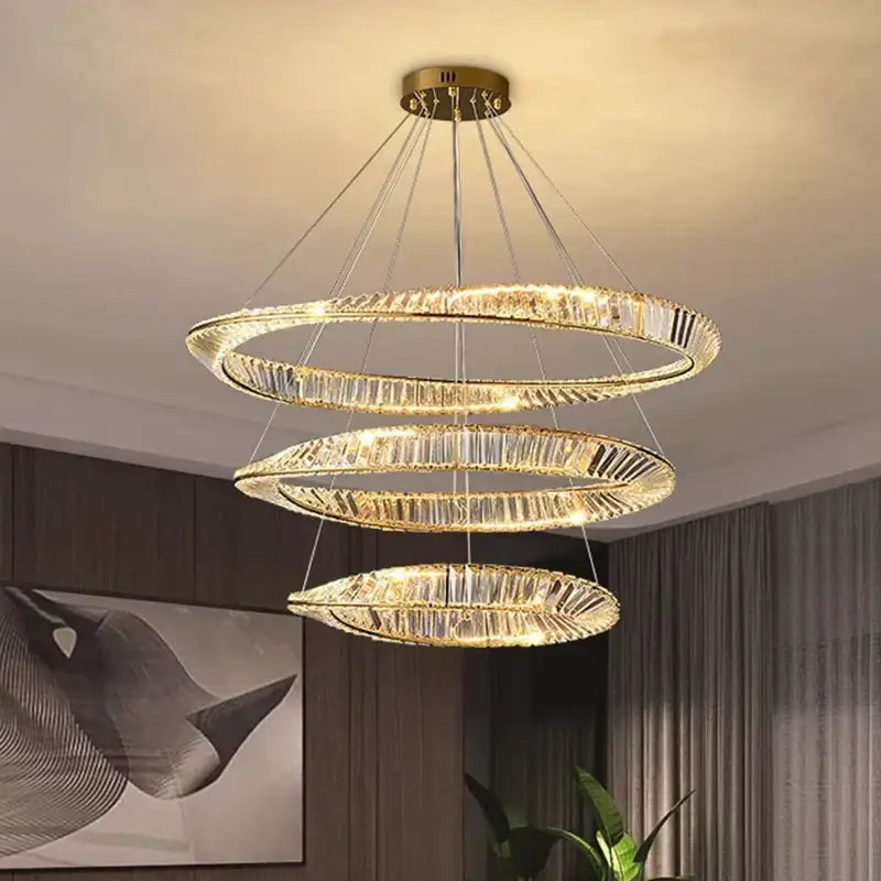 A modern three-tiered decorbites crystal chandelier with gold metal frames and cascading crystals for living spaces