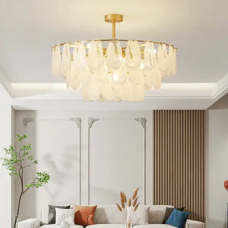 Gold-toned decorbites crystal chandelier with translucent leaf-shaped glass shades in circular pattern for living room and bedroom