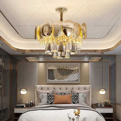 Gold and clear crystal DecorBites crystal chandelier with modern layered design hanging above the bed