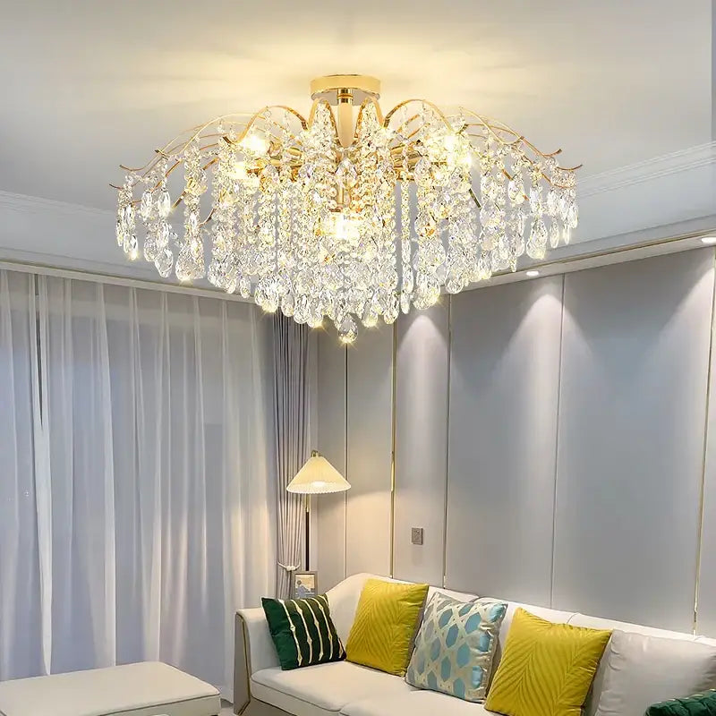 A decorbites crystal chandelier with a gold-toned frame and cascading clear crystals for modern elegance