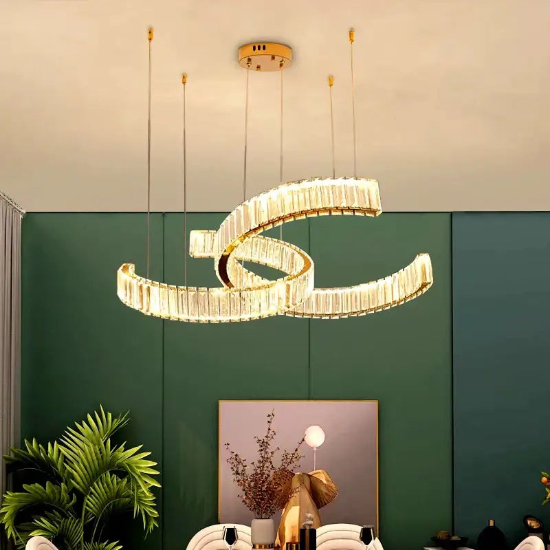 A modern gold-toned decorbites crystal chandelier pendant light with two interlocking spiral rings for home lighting