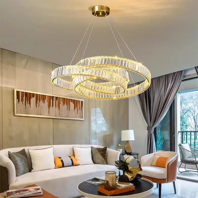 Gold-toned decorbites crystal chandelier with three interlocking crystal rings for modern home and dining room lighting
