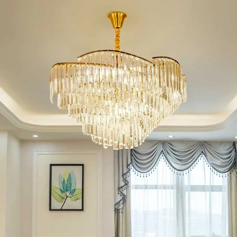 A luxurious gold-toned decorbites crystal chandelier with cascading clear crystal prisms for living room and bedroom