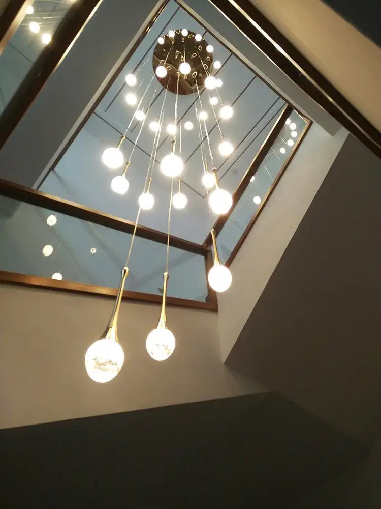 A decorbites crystal chandelier with a circular brass base and gold-toned rods holding spherical glass bulbs
