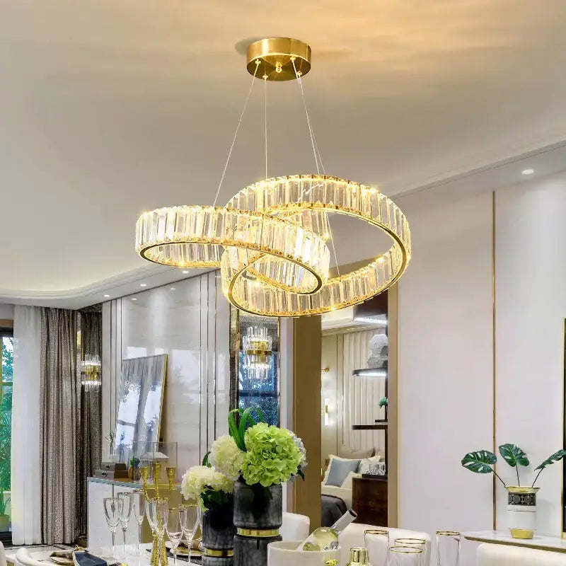 Gold-toned decorbites crystal chandelier with interlocking rings and clear faceted crystals for modern living spaces
