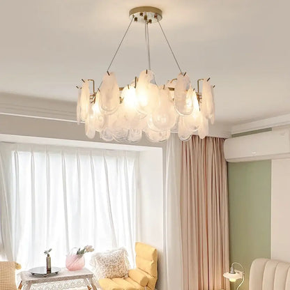A modern decorbites crystal chandelier with frosted glass petals and brass fixture for luxury living spaces