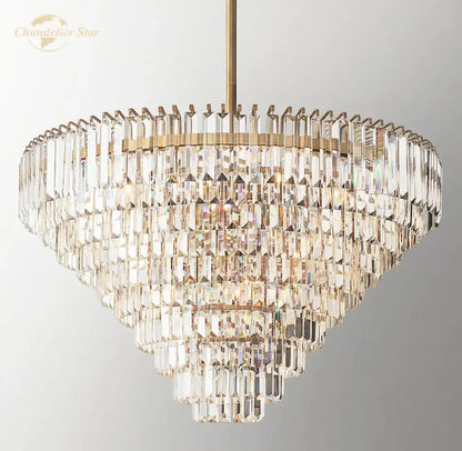 Decorbites crystal chandelier featuring a multi-tiered brass finish with cascading faceted clear crystals refracting light