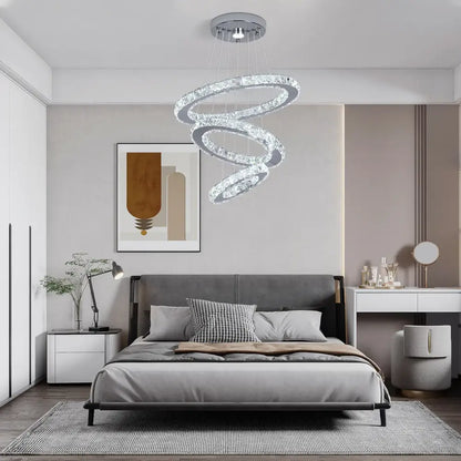 A modern decorbites crystal chandelier pendant lamp with multiple crystal rings and chrome fixture for dining room