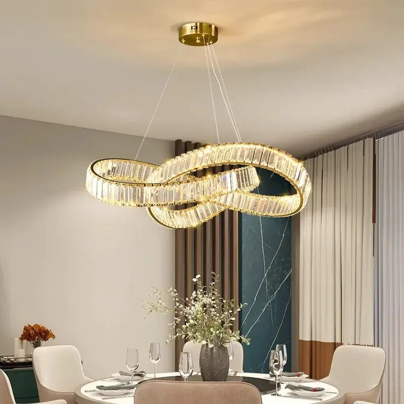 Gold-toned infinity loop chandelier with faceted crystal accents.