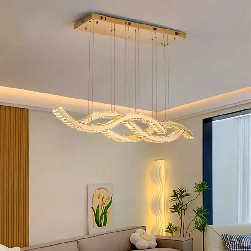 Gold-toned decorbites crystal chandelier pendant light with modern flowing crystals emitting warm ambient light for living room
