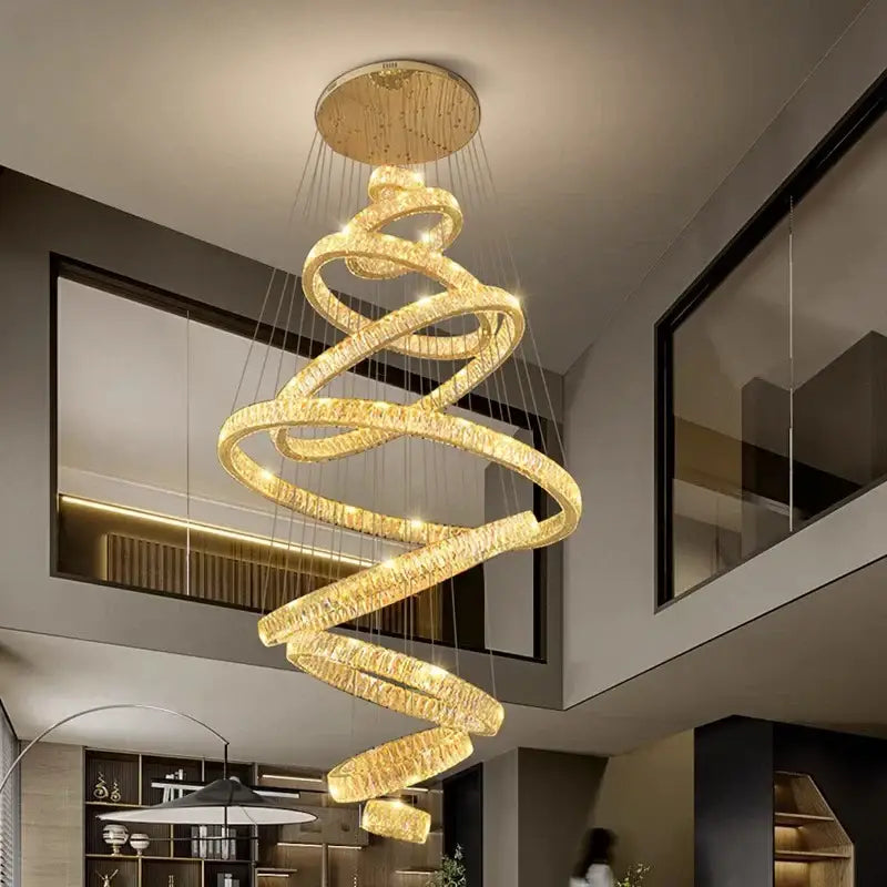 DecorBites crystal chandelier with golden spiral design, crystal-encrusted rings, and polished brass ceiling mount for modern decor