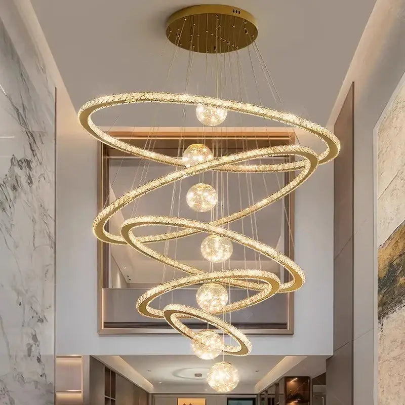 Decorbites crystal chandelier featuring golden spiral design with crystal-encrusted rings and spherical light fixtures
