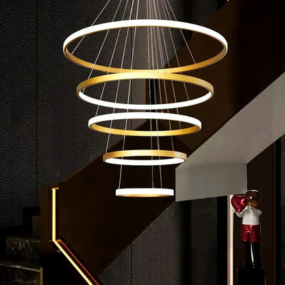 Modern decorbites crystal chandelier stair pendant lamp features alternating gold and white circular rings suspended by cables