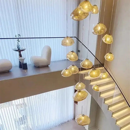 Golden translucent glass pendant lights in a cascading decorbites crystal chandelier stair pendant above staircase