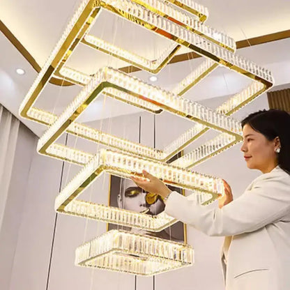 A multi-tiered rectangular decorbites crystal chandelier stair pendant light with gold frames and clear crystal accents