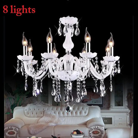 Elegant white DecorBites crystal chandelier with eight lit LED candle lights and dangling teardrop crystals for living rooms