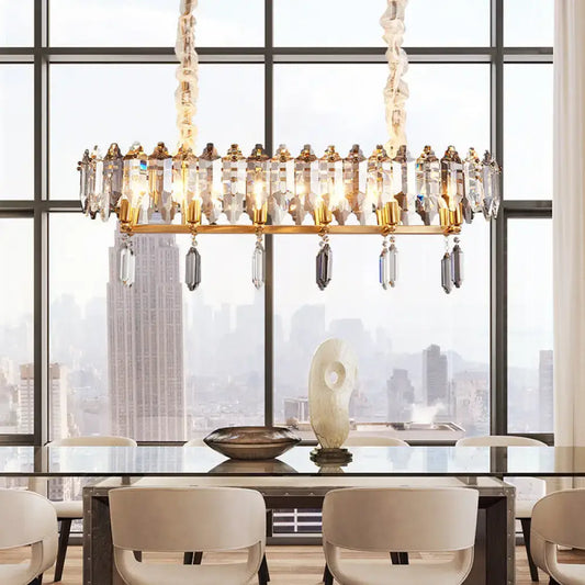 Gold-toned DecorBites™ crystal drop island lighting with modern clear oval design and smoky crystal accents for dining hall