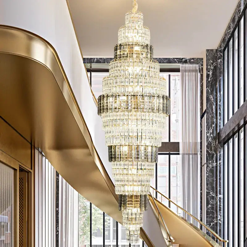 A decorbites crystal duplex multi-tiered crystal chandelier with gold-finished frame hanging in an opulent hallway