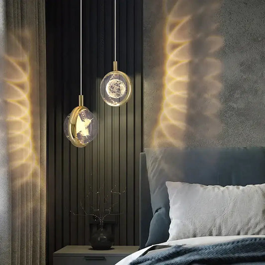 Gold-toned decorbites crystal jellyfish chandelier pendant lights with clear glass globes and wireframe designs above bed