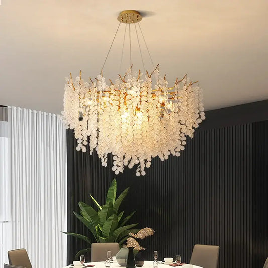 A delicate decorbites crystal led chandelier with translucent white glass flowers and gold frame for dining room lighting