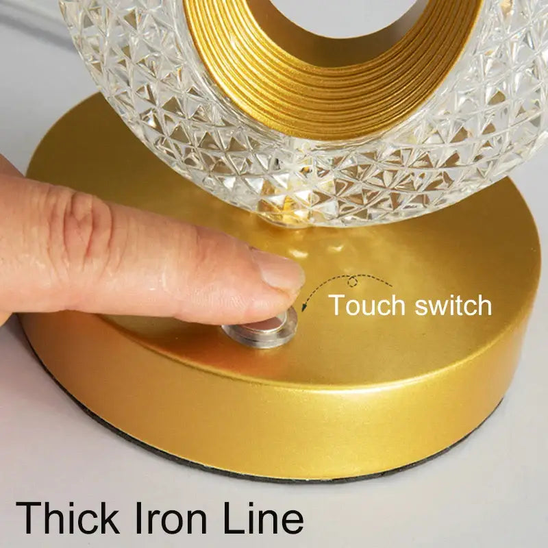 A modern decorbites crystal led table lamp with a gold base and clear faceted crystal glass shade for bedroom use