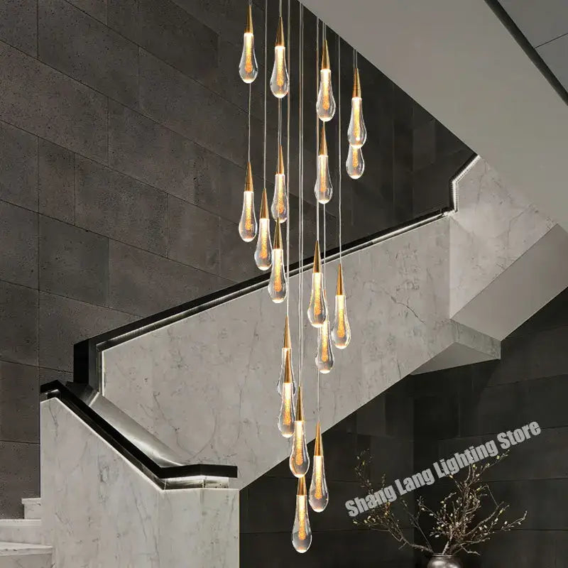 A modern gold crystal luxury ceiling chandelier with teardrop glass pendants and warm glowing interior light