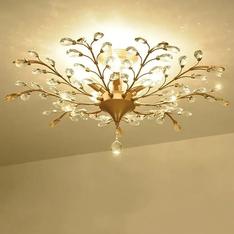 Gold-toned decorbites crystal tree chandelier with intricate branch arms and clear crystal droplets for bedroom lighting
