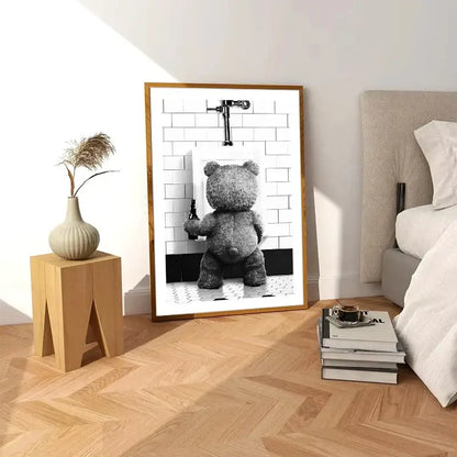 A framed black-and-white canvas print featuring a cute bear bathroom scene with a gray teddy bear and white tiles
