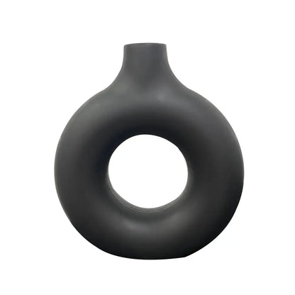 A sleek matte black ceramic donut shape flower vase with a modern minimalist design and narrow neck by decorbites