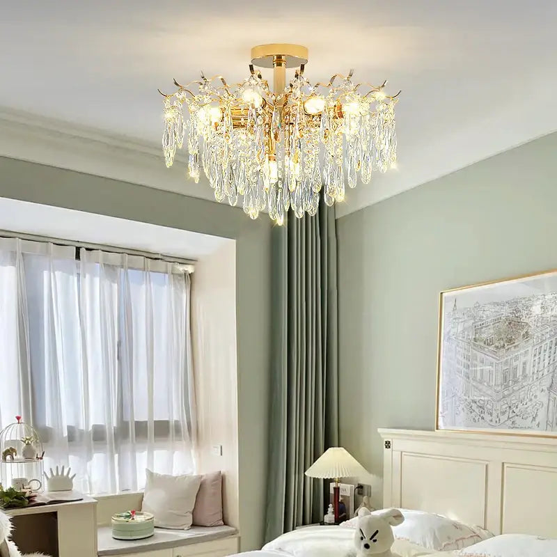 Gold-toned Decorbites elegant crystal chandelier with cascading crystal droplets and warm glowing bulbs for dining room