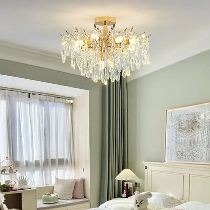 Gold-toned Decorbites elegant crystal chandelier with cascading crystal droplets and warm glowing bulbs for dining room
