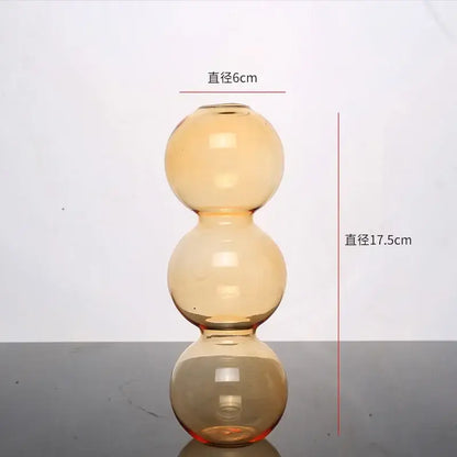 Amber-colored DecorBites™ elegant glass vase with three stacked spherical sections for stylish home decor accent