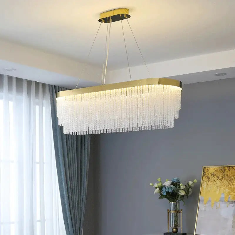Gold-framed rectangular crystal chandelier with cascading clear strands featuring modern gold luster for home lighting