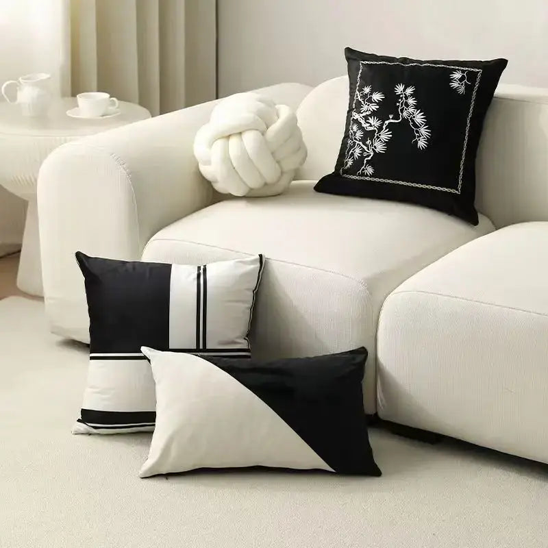 Decorbites embroidered black and white cushion cover with floral and geometric patterns on a modern living room sofa
