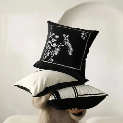 Decorbites embroidered black white cushion cover featuring a black pillow with white pine branch embroidery and stitched border